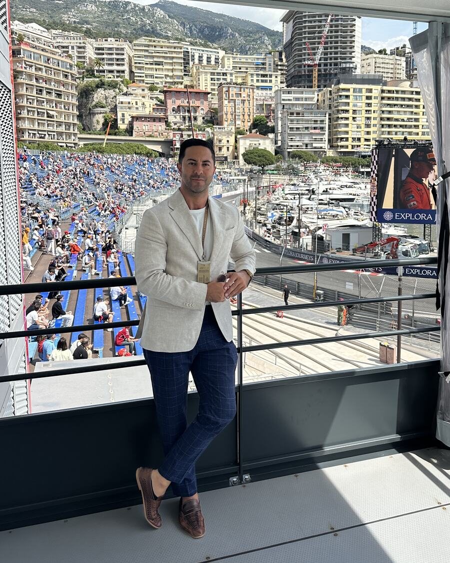 Adam Agresta in a cream blazer above the Monaco harbour