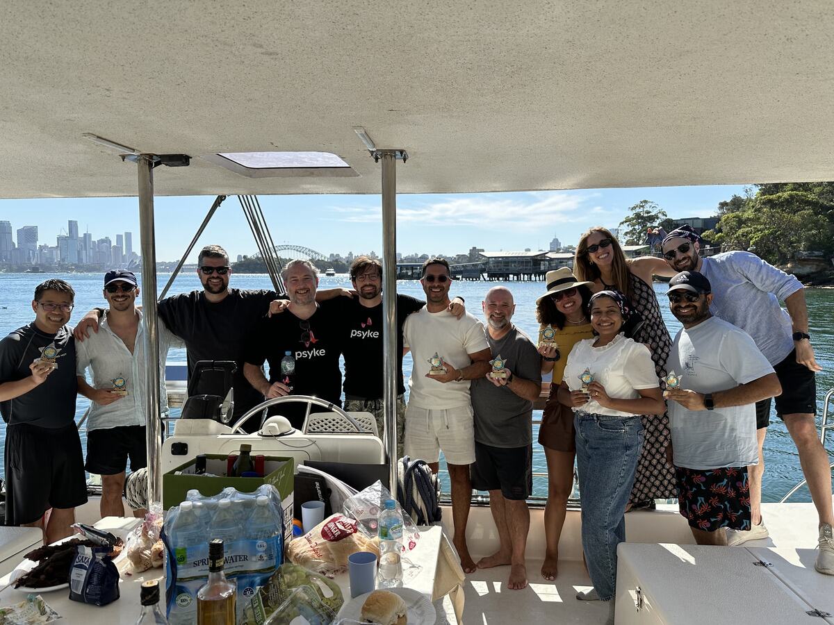 Adam with the Psyke team on a boat on Sydney Harbour